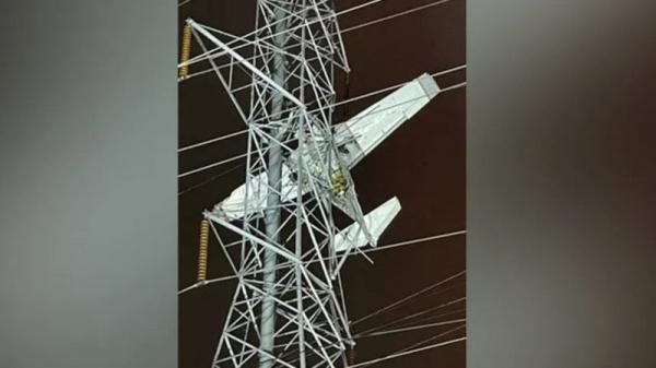 Avião bate em torre de transmissão de energia e pilotos ficam presos a 24 metros do chão